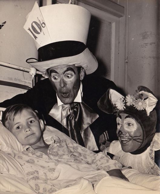 the Mad Hatter played by John Jones and the March Hare played by Geoff Snell visiting a young patient at the Base Hospital Childrens Ward